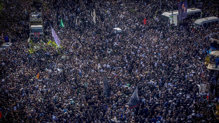 Iranians follow a truck carrying coffins of the late President Ebrahim Raisi and his companions, who were killed in a helicopter crash, during a funeral ceremony for them on May 22, 2024, in Tehran, Iran. 